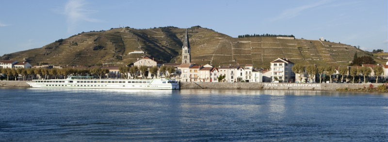 Ms Camargue river cruise ship on the calm water of the river with a beautiful landscape in the background.